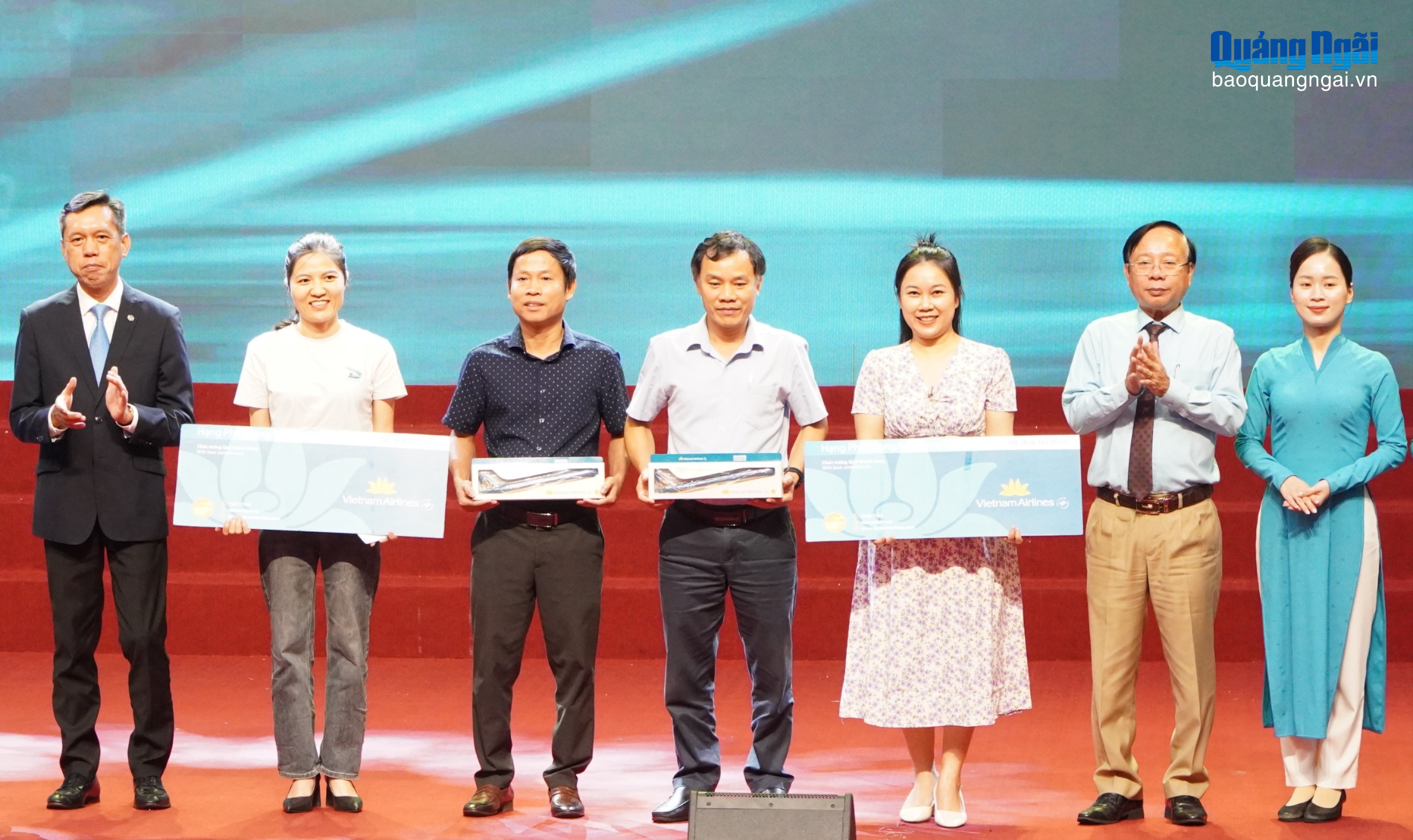 Trưởng Ban Quản lý KKT Dung Quất và các KCN Quảng Ngãi và đại diện Vietnam Airlines trao quà cho các đại biểu bốc thăm may mắn tại hội nghị.