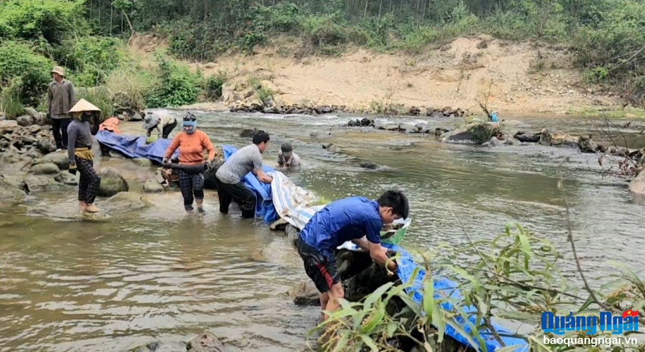 Người dân dùng đá, đất và tấm bạt,… chặn một đoạn sông ngắn, ngăn đôi dòng nước để bắt cá.